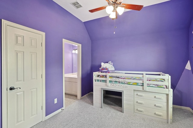 bedroom featuring vaulted ceiling, light colored carpet, ensuite bathroom, and ceiling fan