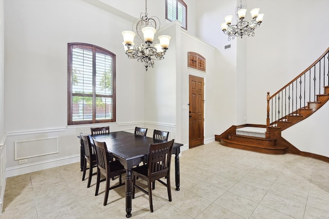 tiled dining room with a towering ceiling and a notable chandelier