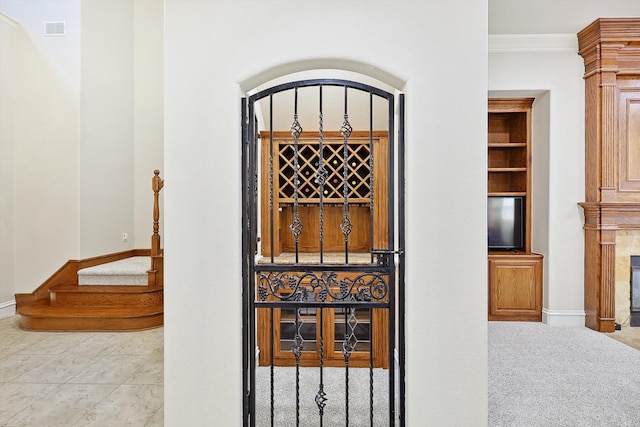 interior space with built in features, ornamental molding, and tile patterned floors