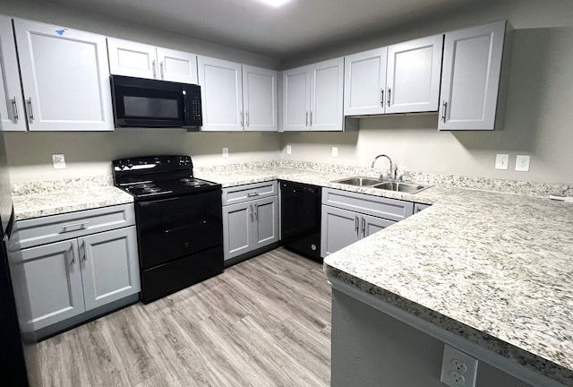 kitchen featuring gray cabinets, light hardwood / wood-style floors, sink, and black appliances