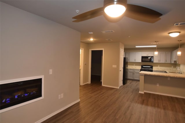 kitchen featuring pendant lighting, black appliances, dark hardwood / wood-style flooring, light stone countertops, and ceiling fan