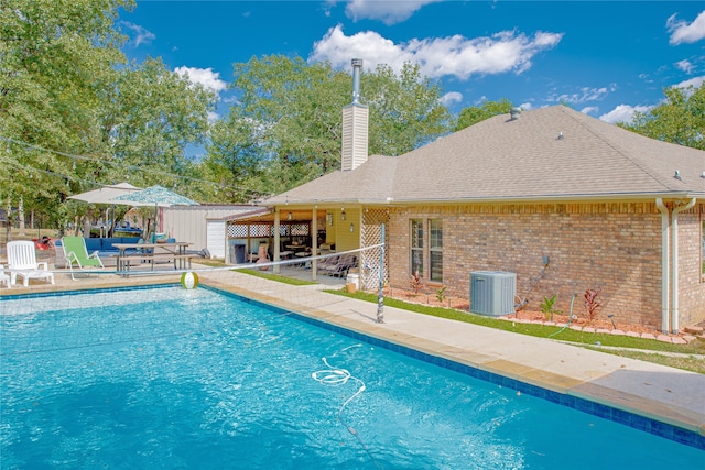 view of swimming pool featuring a patio and central air condition unit