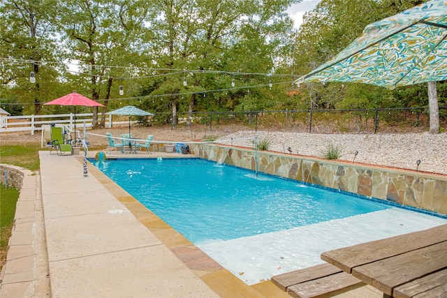 view of swimming pool featuring pool water feature and a patio area