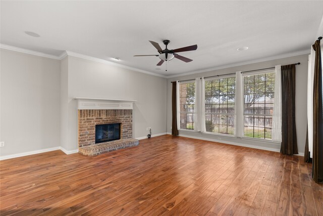 unfurnished living room featuring a fireplace, crown molding, hardwood / wood-style floors, and ceiling fan