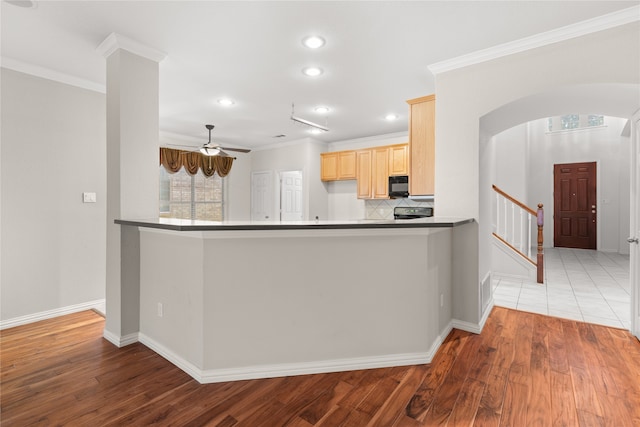 kitchen with light wood-type flooring, crown molding, ceiling fan, decorative backsplash, and light brown cabinets