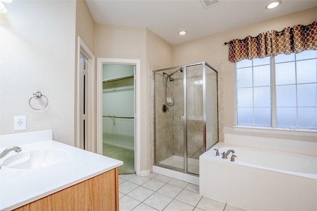 bathroom featuring vanity, plus walk in shower, and tile patterned flooring