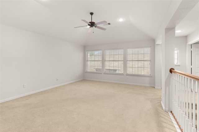 unfurnished room with light colored carpet, ceiling fan, and vaulted ceiling