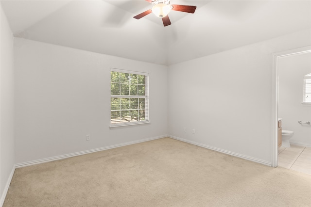 empty room featuring light colored carpet, vaulted ceiling, and ceiling fan