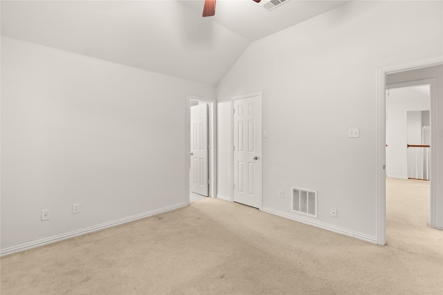 empty room featuring lofted ceiling, ceiling fan, and light carpet