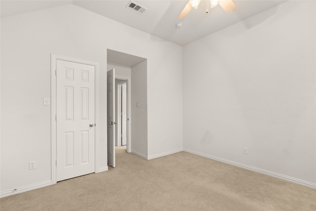 unfurnished room with vaulted ceiling, light colored carpet, and ceiling fan