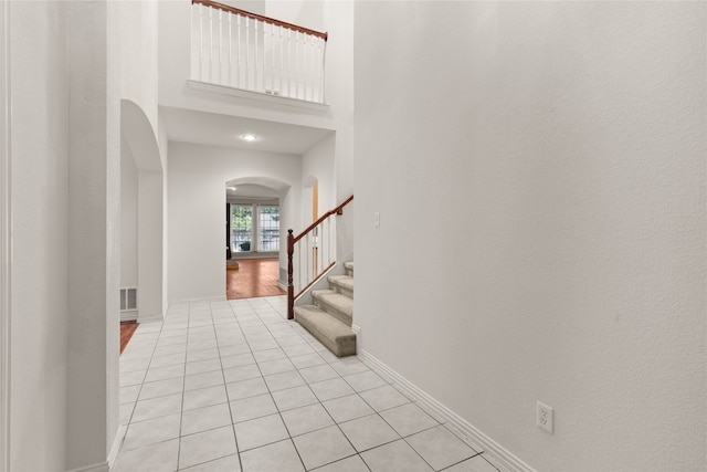 entrance foyer with a towering ceiling and light hardwood / wood-style flooring