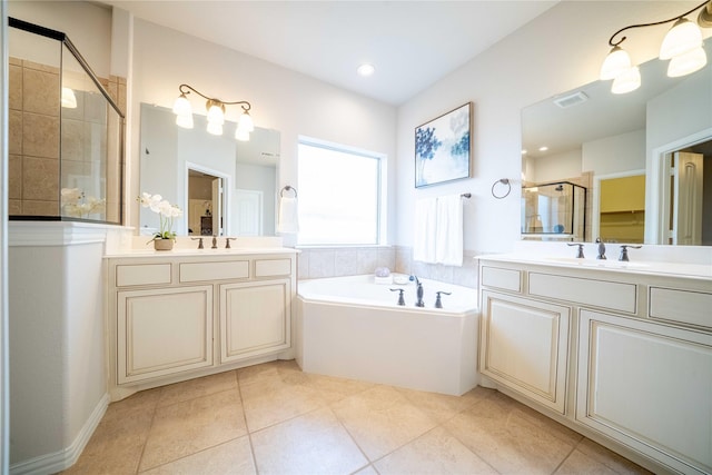 full bath with tile patterned flooring, a garden tub, a sink, two vanities, and a shower stall