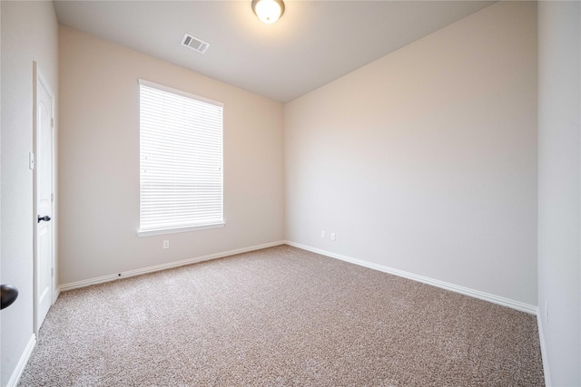 carpeted spare room with visible vents and baseboards