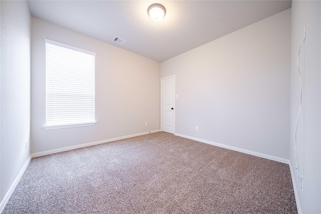 carpeted empty room with visible vents and baseboards