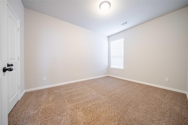 carpeted spare room with visible vents and baseboards