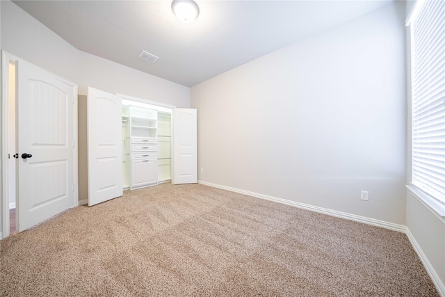 unfurnished bedroom featuring light carpet, a closet, visible vents, and baseboards