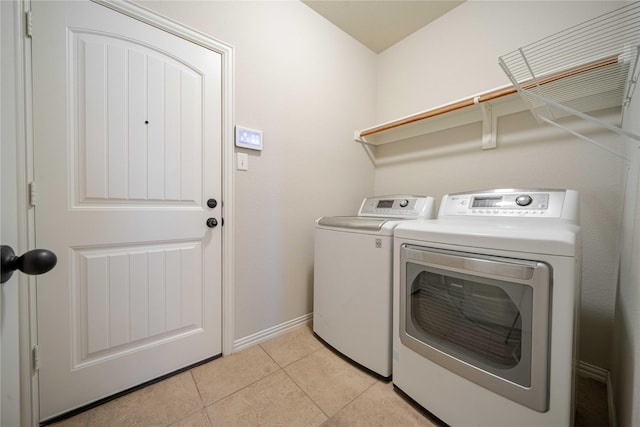 laundry room featuring light tile patterned floors, laundry area, independent washer and dryer, and baseboards