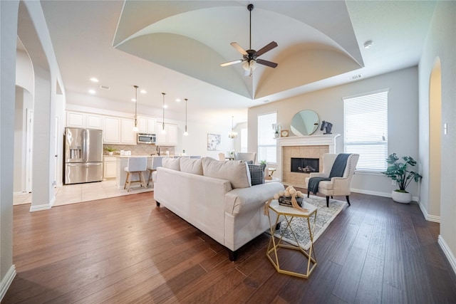 living room with visible vents, a fireplace, hardwood / wood-style floors, and ceiling fan