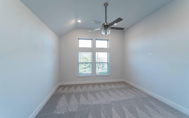 carpeted spare room with ceiling fan and vaulted ceiling