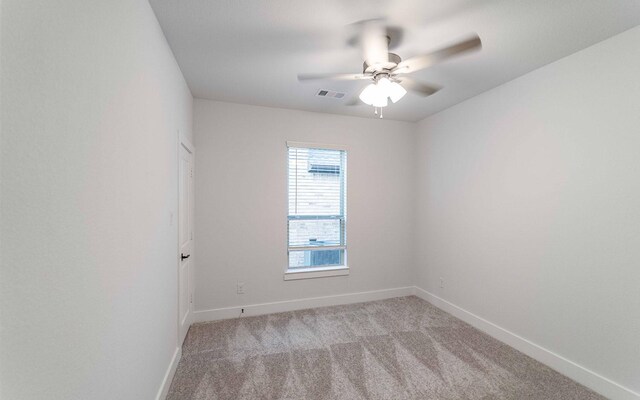 spare room featuring light carpet and ceiling fan