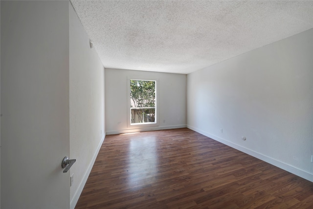 unfurnished room with dark hardwood / wood-style floors and a textured ceiling