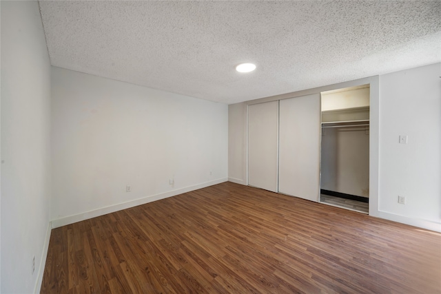 unfurnished bedroom featuring a textured ceiling, wood-type flooring, and a closet