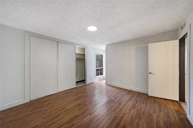 unfurnished bedroom featuring dark hardwood / wood-style floors and a textured ceiling