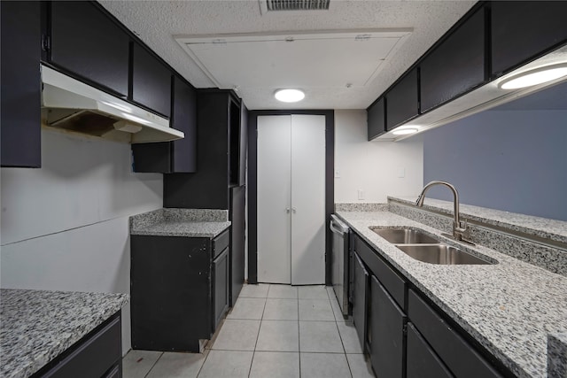 kitchen featuring stainless steel dishwasher, light stone countertops, sink, and light tile patterned flooring