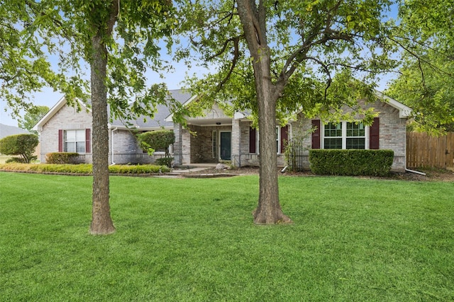 view of front of property with brick siding, fence, and a front yard