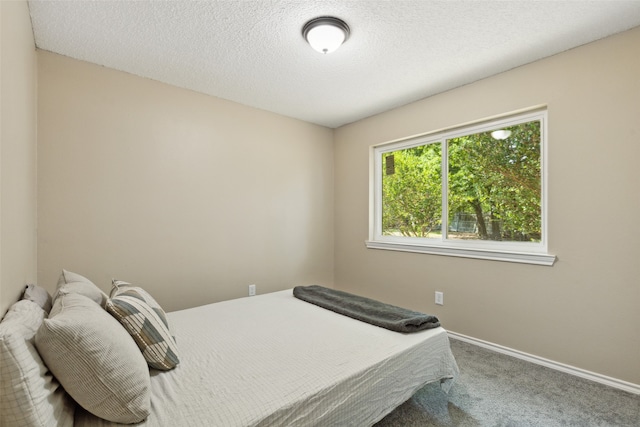 bedroom featuring a textured ceiling and carpet flooring