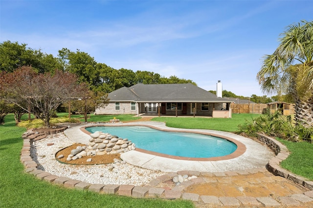 pool with a lawn, a patio area, and fence