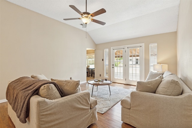 living room featuring lofted ceiling, ceiling fan, hardwood / wood-style floors, and french doors