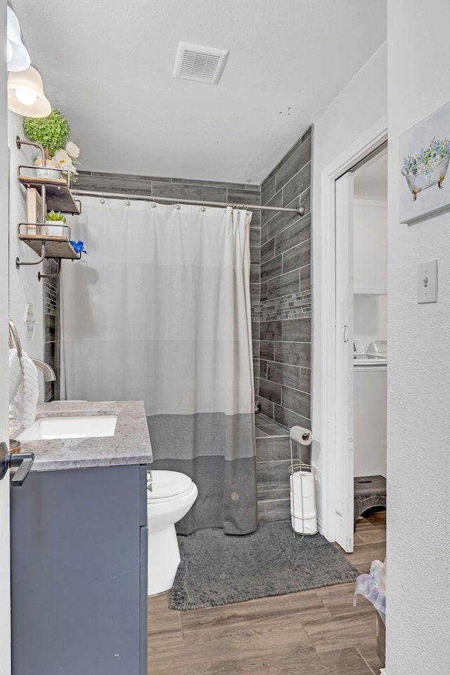 full bath with toilet, wood finished floors, vanity, visible vents, and a shower with curtain