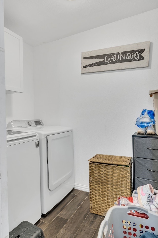 washroom featuring laundry area, washing machine and dryer, baseboards, and wood finish floors