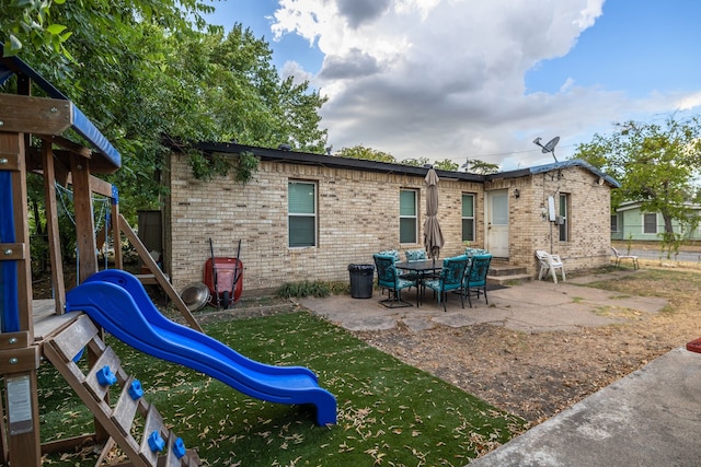 back of house featuring central AC unit and a trampoline