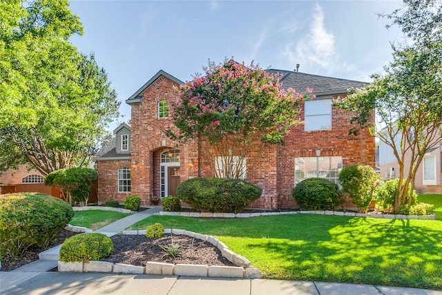 traditional-style house with brick siding and a front lawn