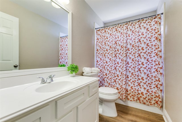 bathroom featuring toilet, wood finished floors, and vanity