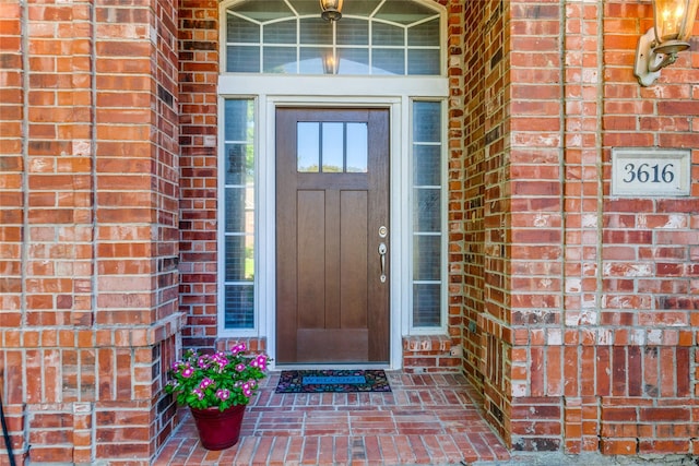 entrance to property featuring brick siding