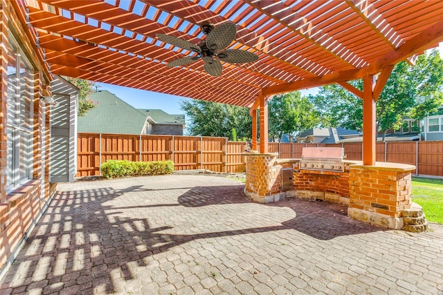 view of patio / terrace featuring grilling area, a ceiling fan, fence, a pergola, and exterior kitchen