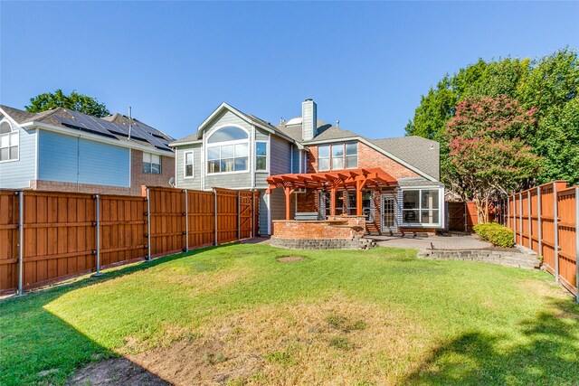 back of property with a yard, a patio area, and a pergola