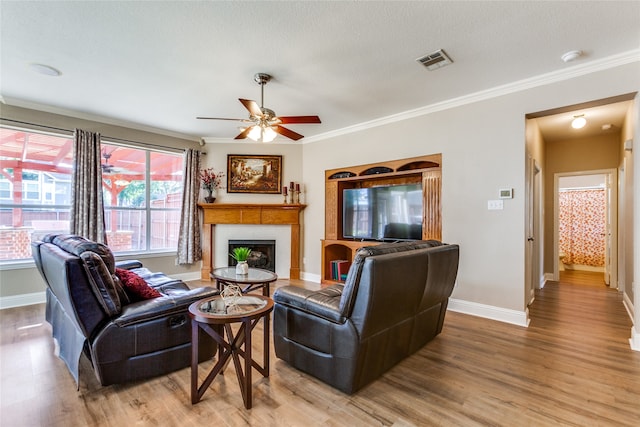 living room featuring a wealth of natural light, ornamental molding, and hardwood / wood-style flooring