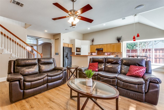 living room with high vaulted ceiling, light hardwood / wood-style flooring, and ceiling fan