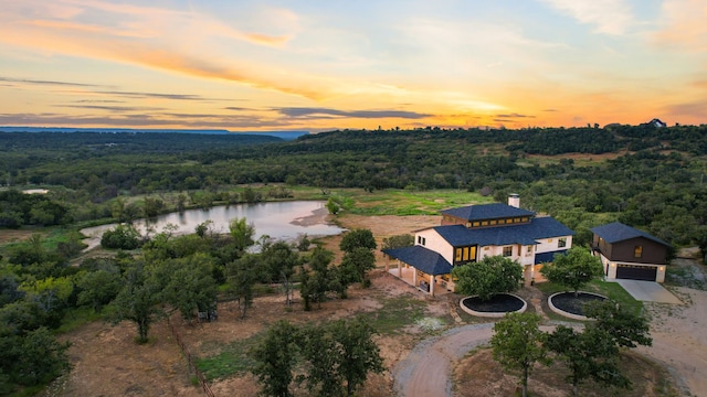 aerial view at dusk featuring a water view