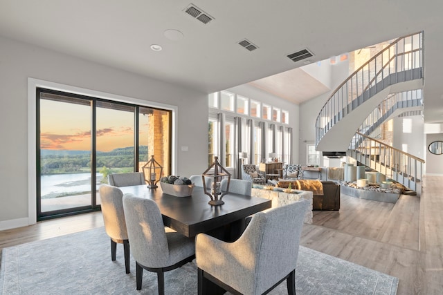 dining room with hardwood / wood-style floors and a water view