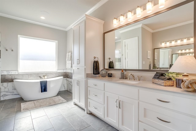 bathroom with tile patterned floors, ornamental molding, a washtub, vanity, and tile walls