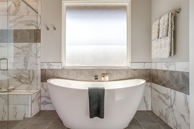 bathroom with tile walls and independent shower and bath