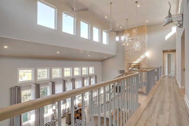 corridor featuring light hardwood / wood-style flooring, high vaulted ceiling, and wooden ceiling