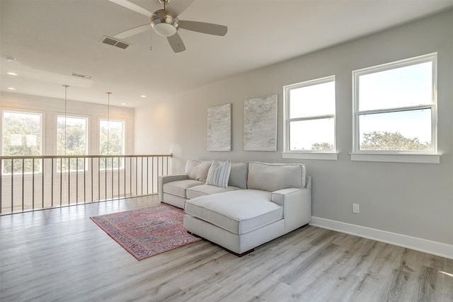 living room with ceiling fan, light hardwood / wood-style flooring, and a healthy amount of sunlight