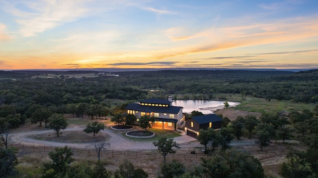 aerial view at dusk featuring a water view