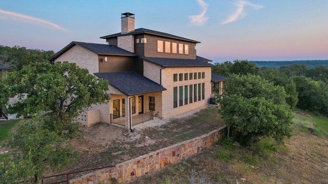 back house at dusk with covered porch